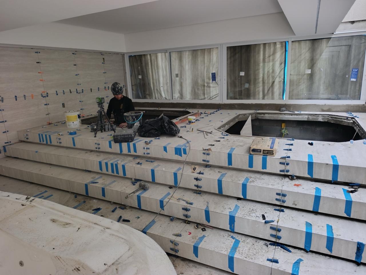 Profissional da Construtora Empório assentando porcelanato